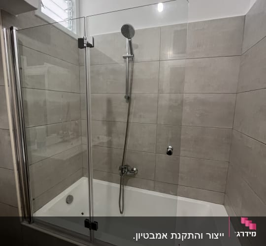 אמבטיון זכוכית שקופה מותקן על גבי אמבטיה בחדר רחצה